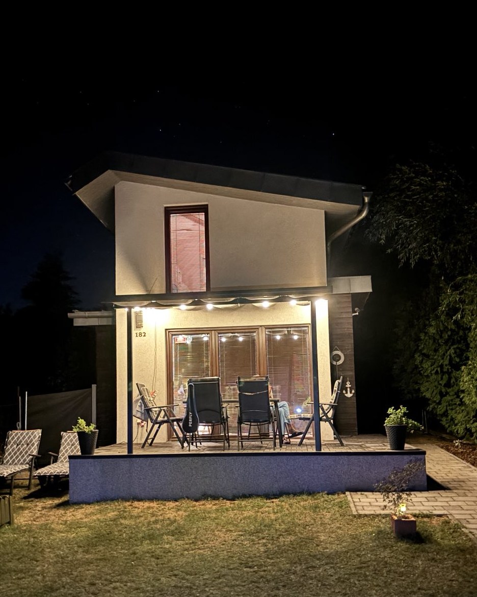 A Palatinus Apartman háza este, meleg fényekkel és terasszal